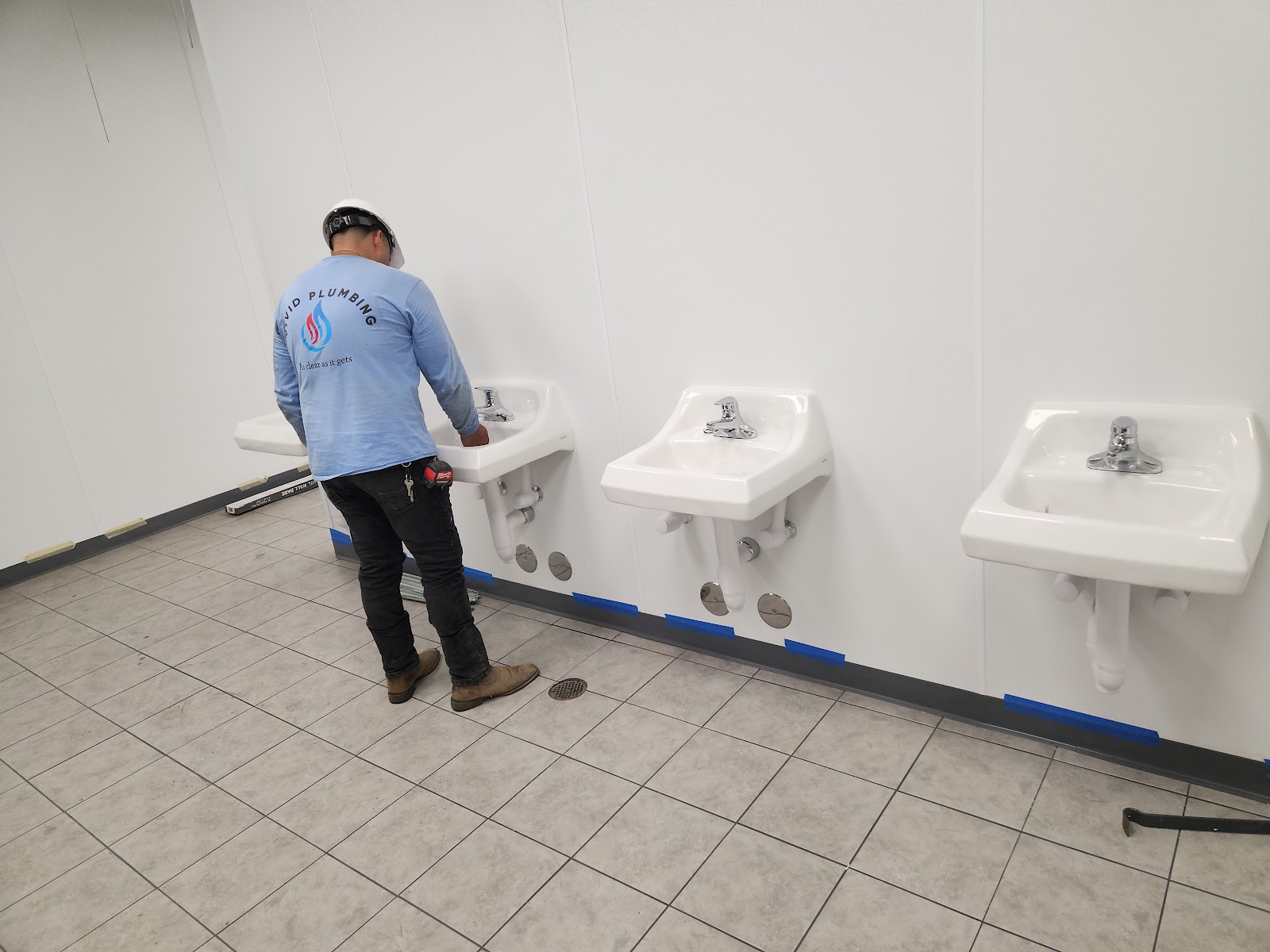 Vivid tech installing wall-hung sinks in a commercial restroom