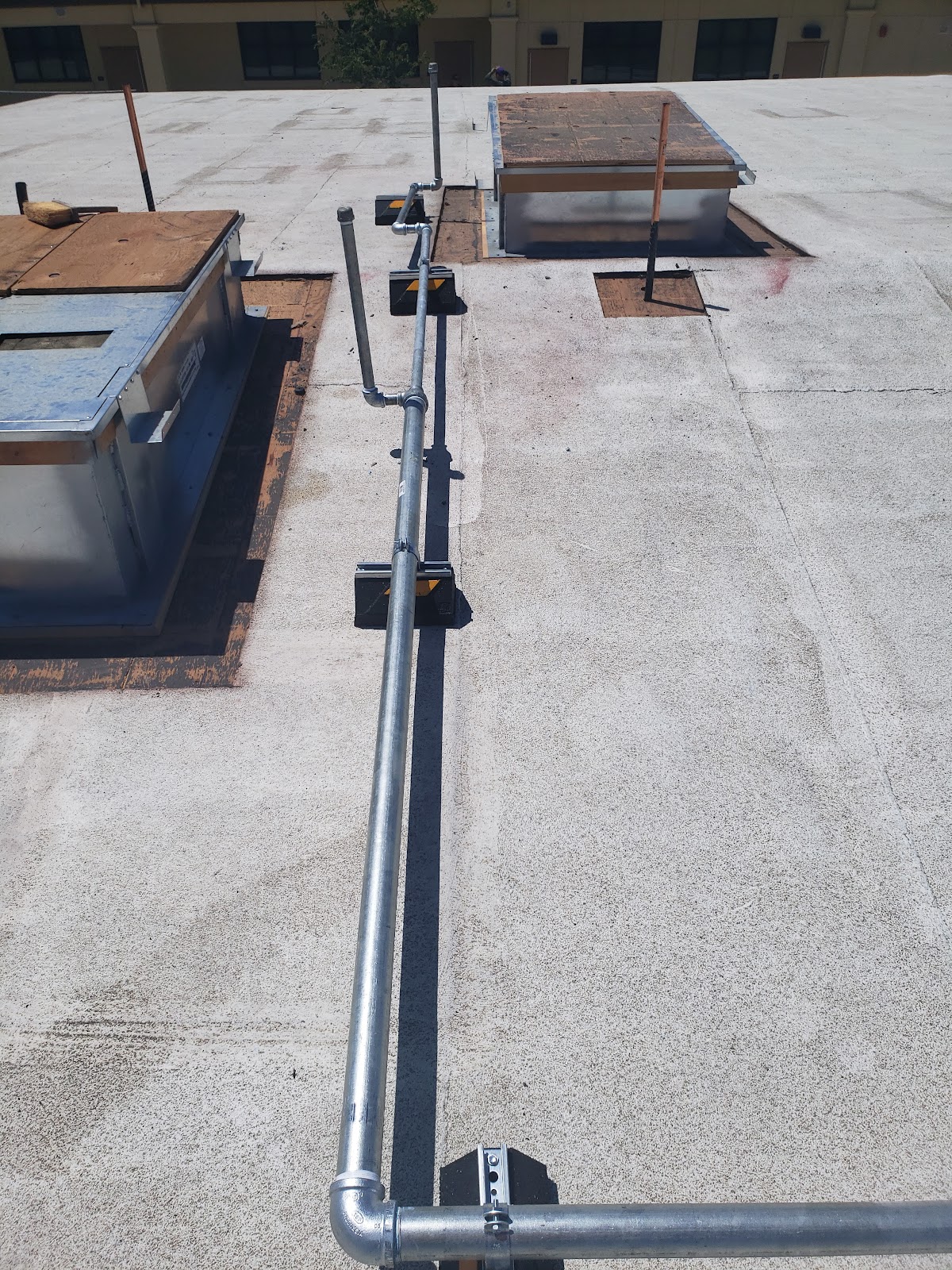 Galvanized rooftop gas line run on a commercial building