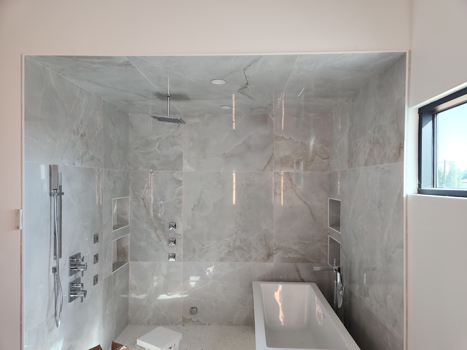 Luxury marble walk-in shower and freestanding tub installed by Vivid Plumbing